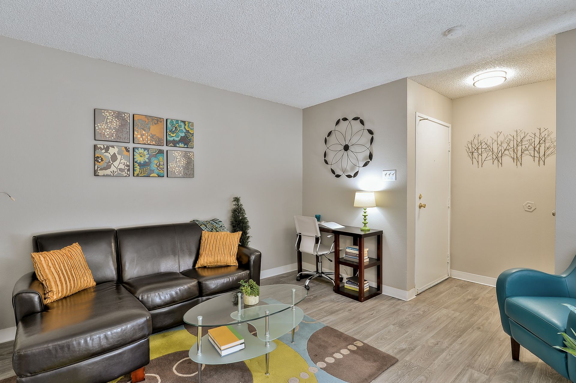 A living room with a couch , chair , coffee table and desk The Park at Idlewild. 