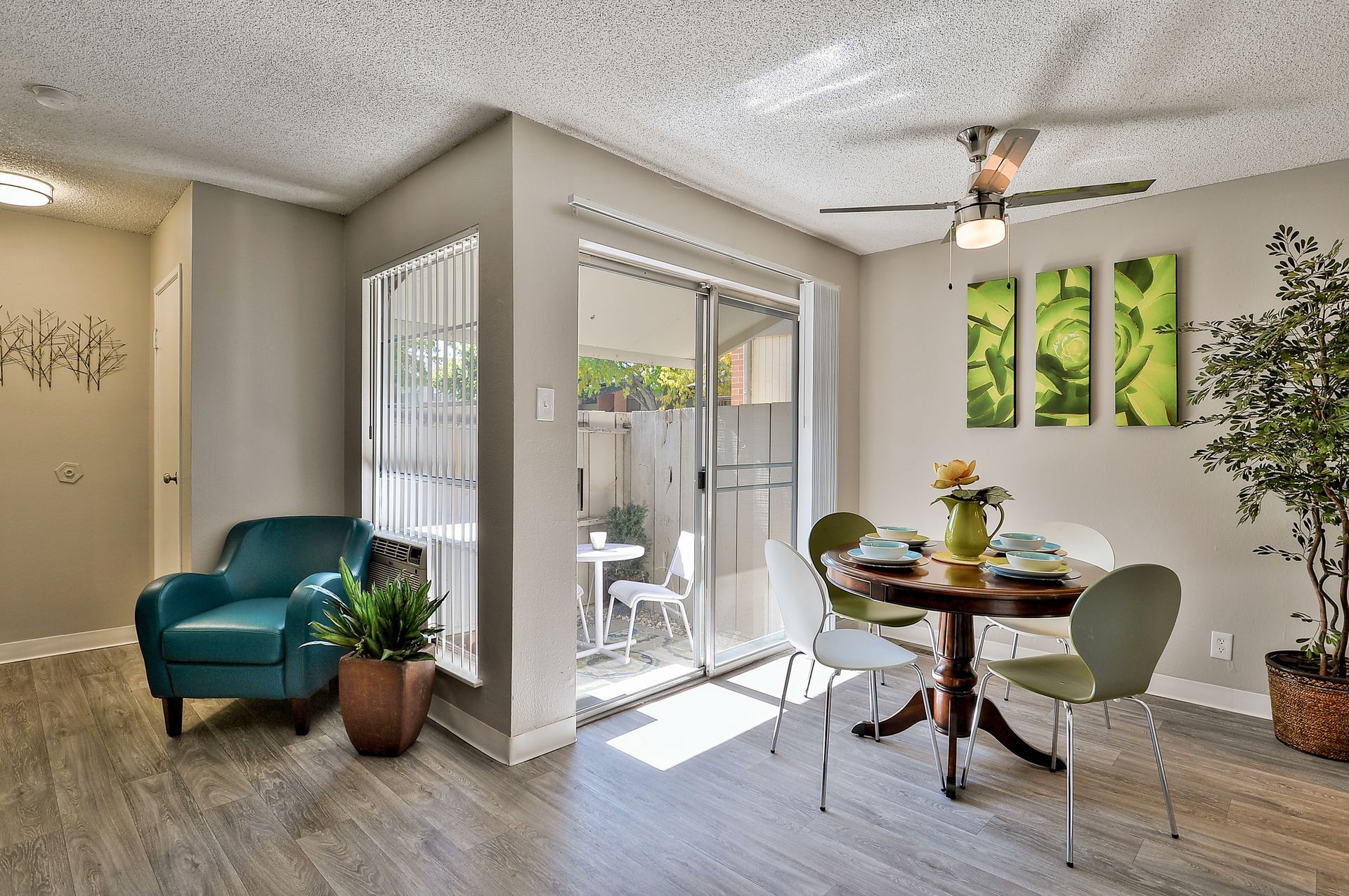 A living room with a table and chairs and a ceiling fan The Park at Idlewild. 