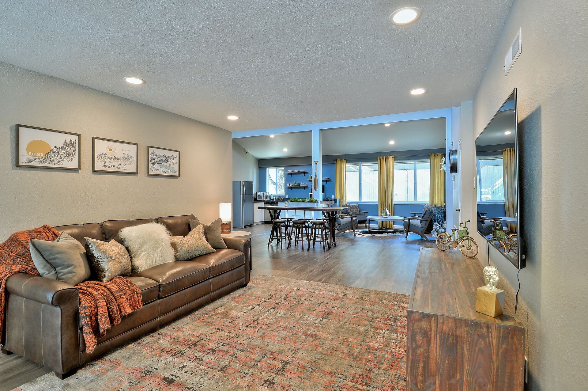 A living room with a large couch and a flat screen tv at The Park at Idlewild. 