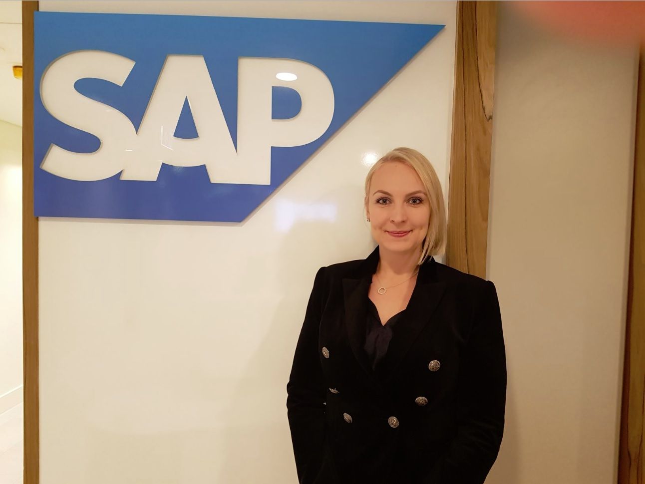 A woman is standing in front of a sign that says sap
