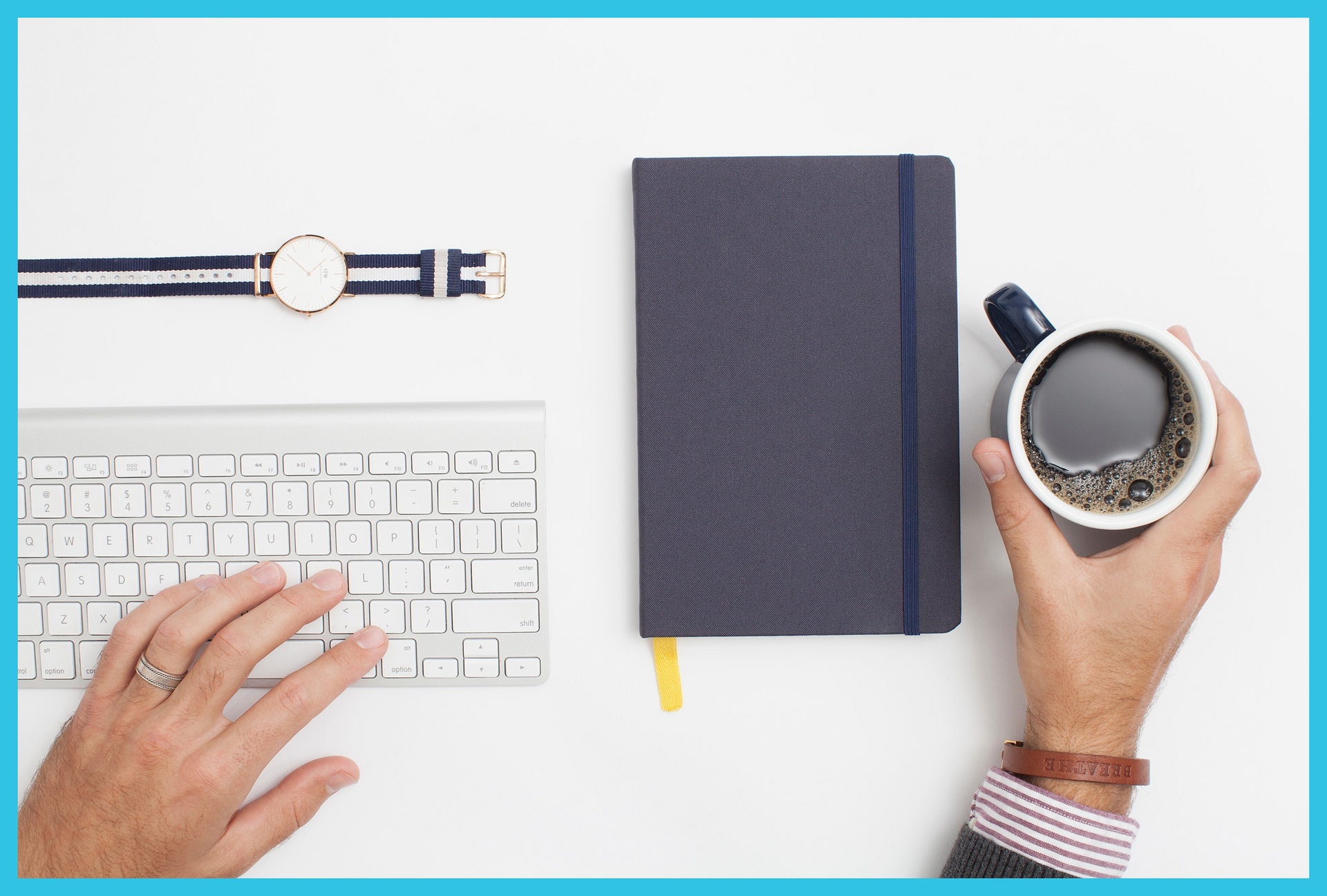 A person is typing on a keyboard while holding a cup of coffee.