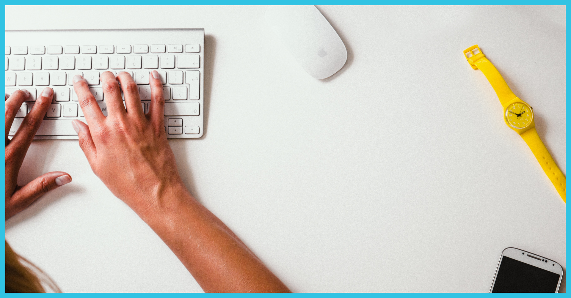 A person is typing on a white keyboard next to a yellow watch.