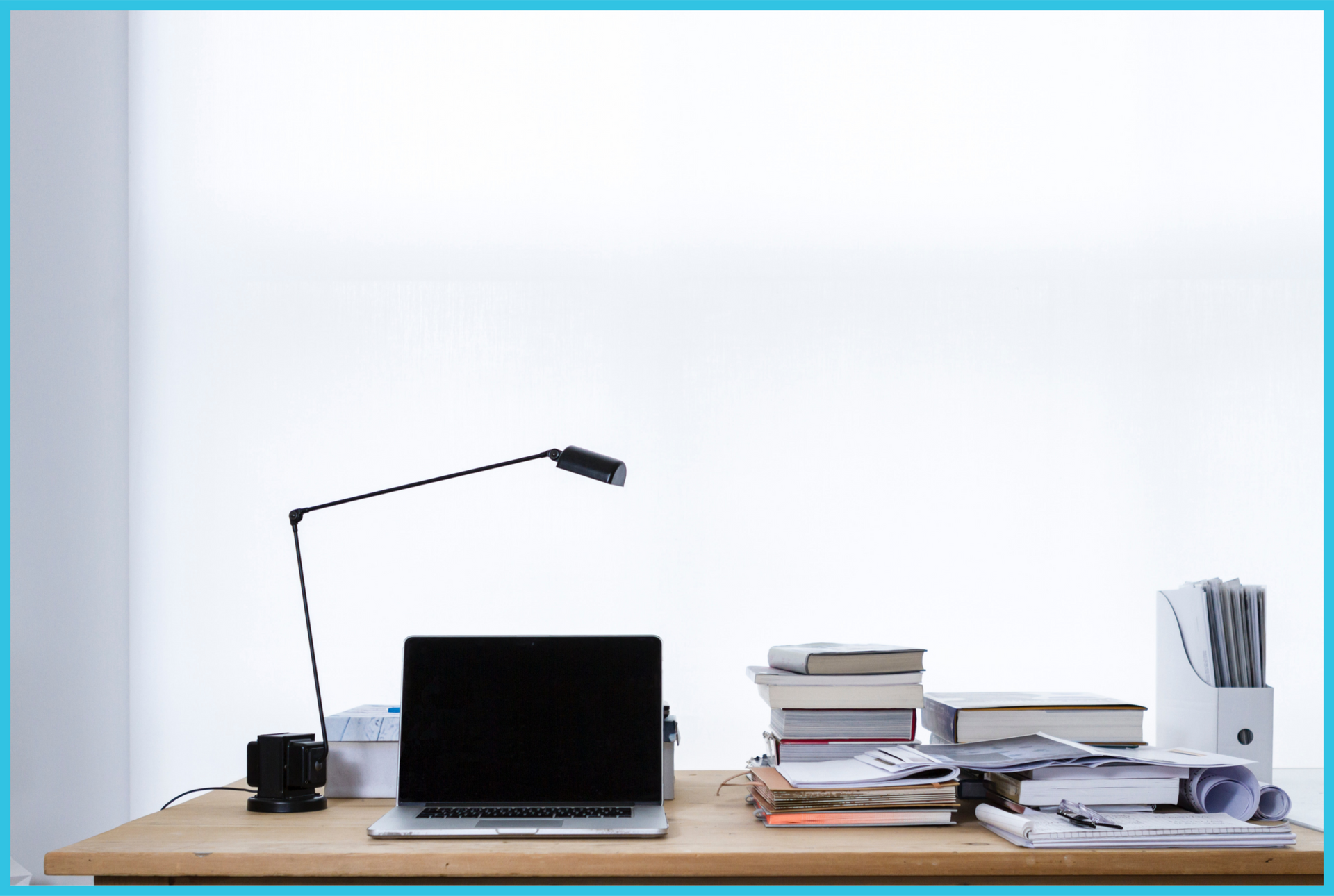 A desk with a laptop and a lamp on it