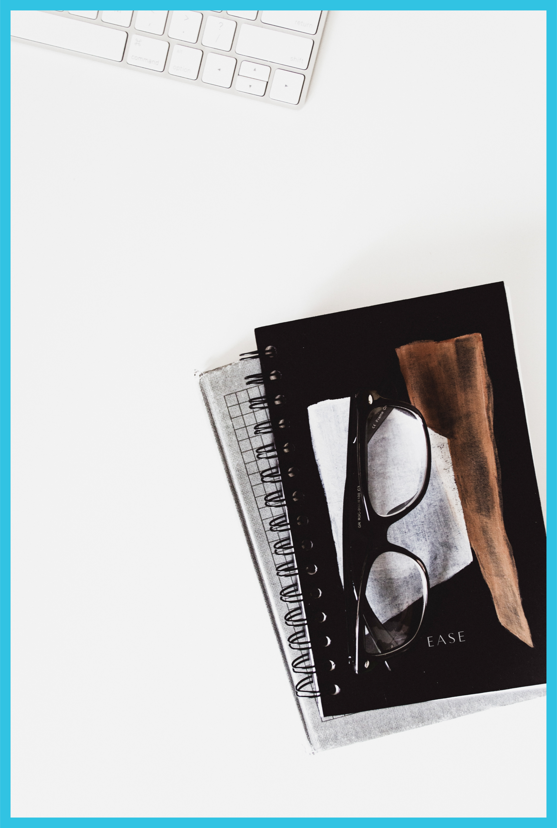 A pair of glasses sits on top of a spiral notebook