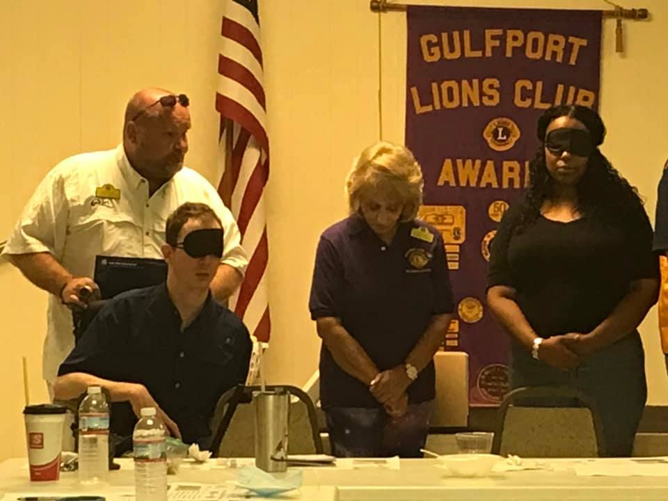People blindfolded, tasting food at a Gulfport Lions Club event.