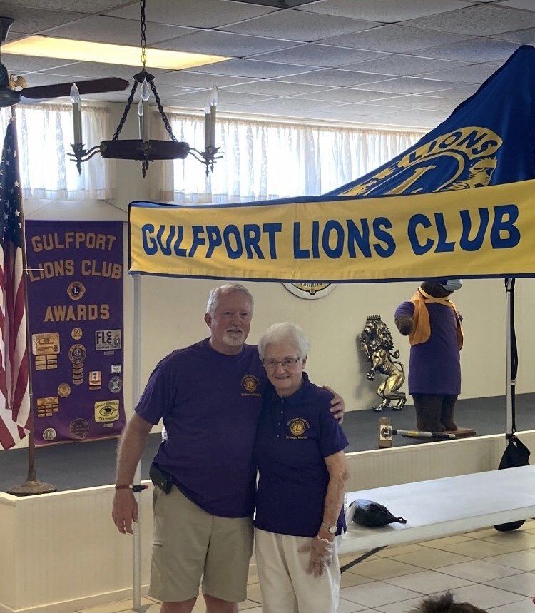 Two people posing in front of a 