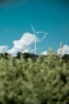 A wind turbine is sitting in the middle of a field.