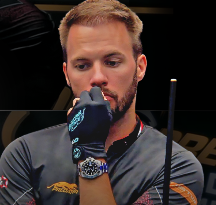 Person arranging billiard balls with a triangle rack on a green pool table, preparing for a game.