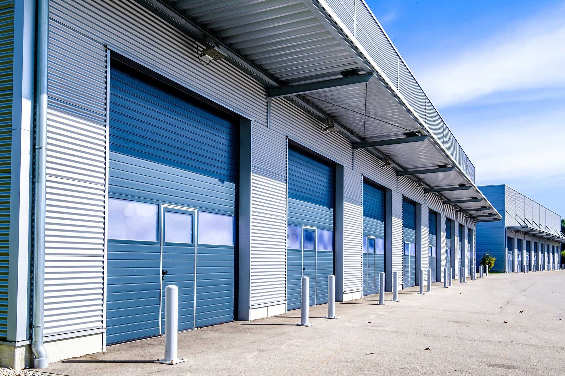 A row of blue garage doors on a building