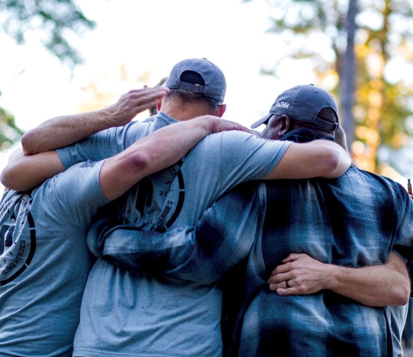 Soldier in camouflage with a German Shepherd dog overlooking a body of water. Sunny day.