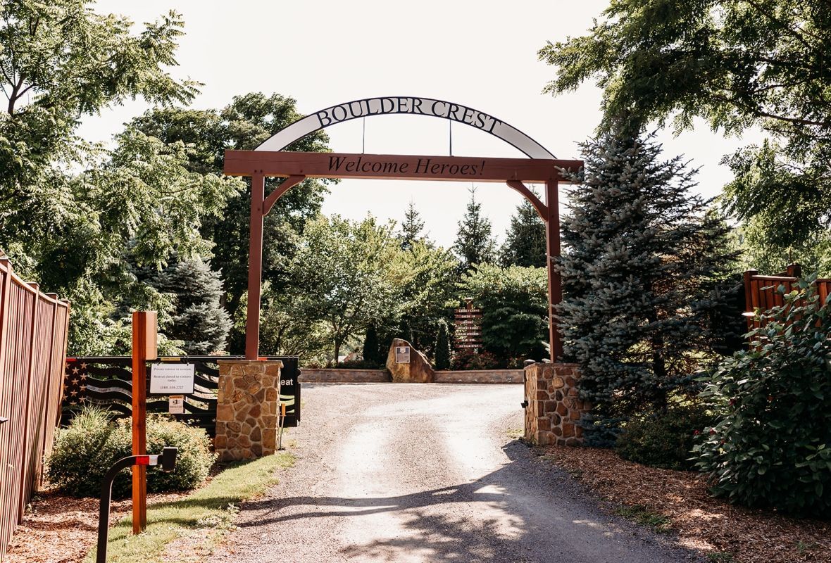 Soldier in camouflage with a German Shepherd dog overlooking a body of water. Sunny day.