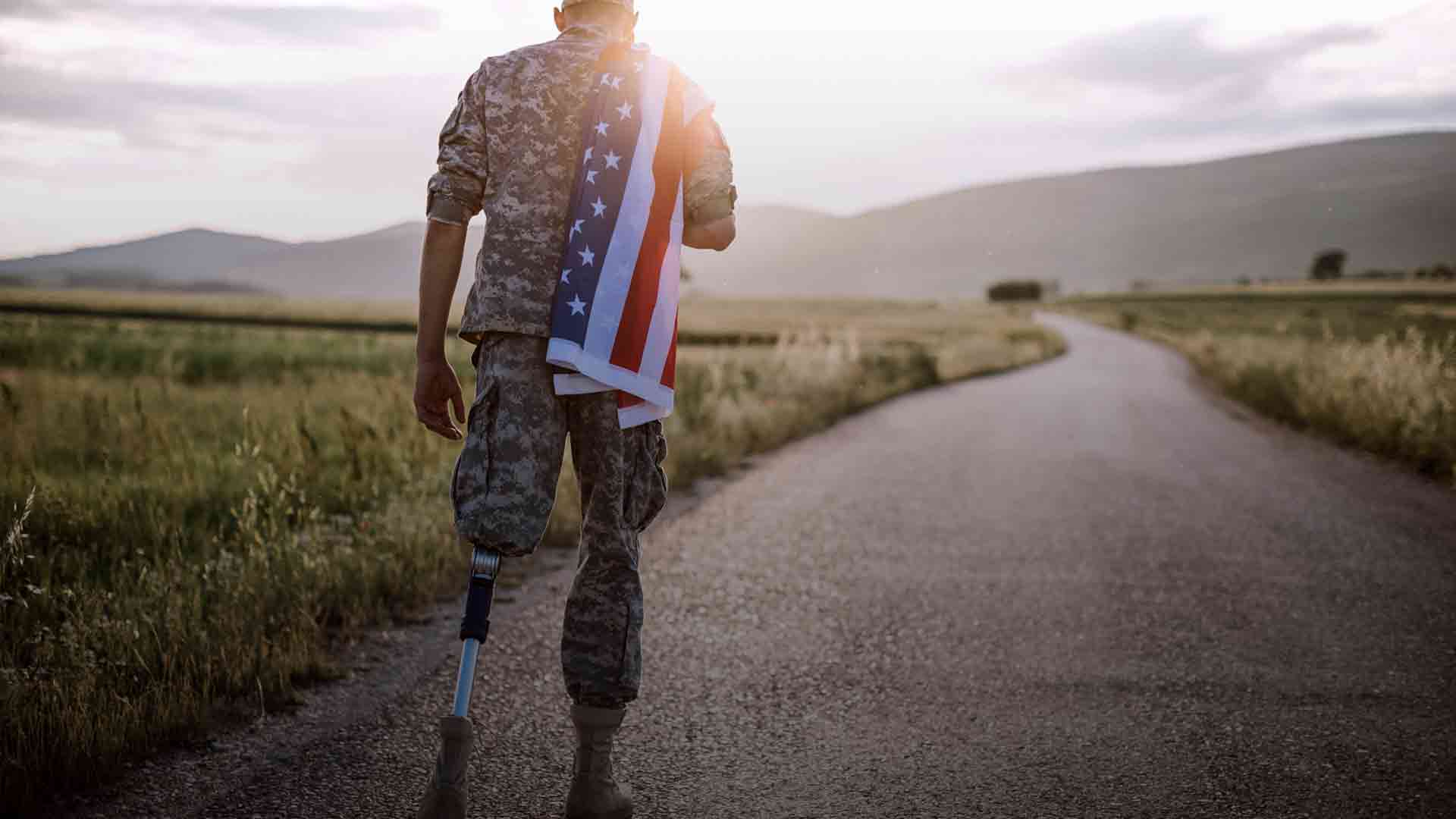 Soldier in camouflage with a German Shepherd dog overlooking a body of water. Sunny day.