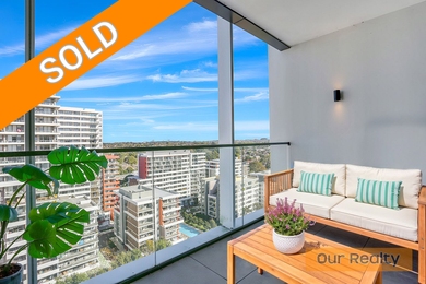 A balcony with a couch and a table with a view of a city.