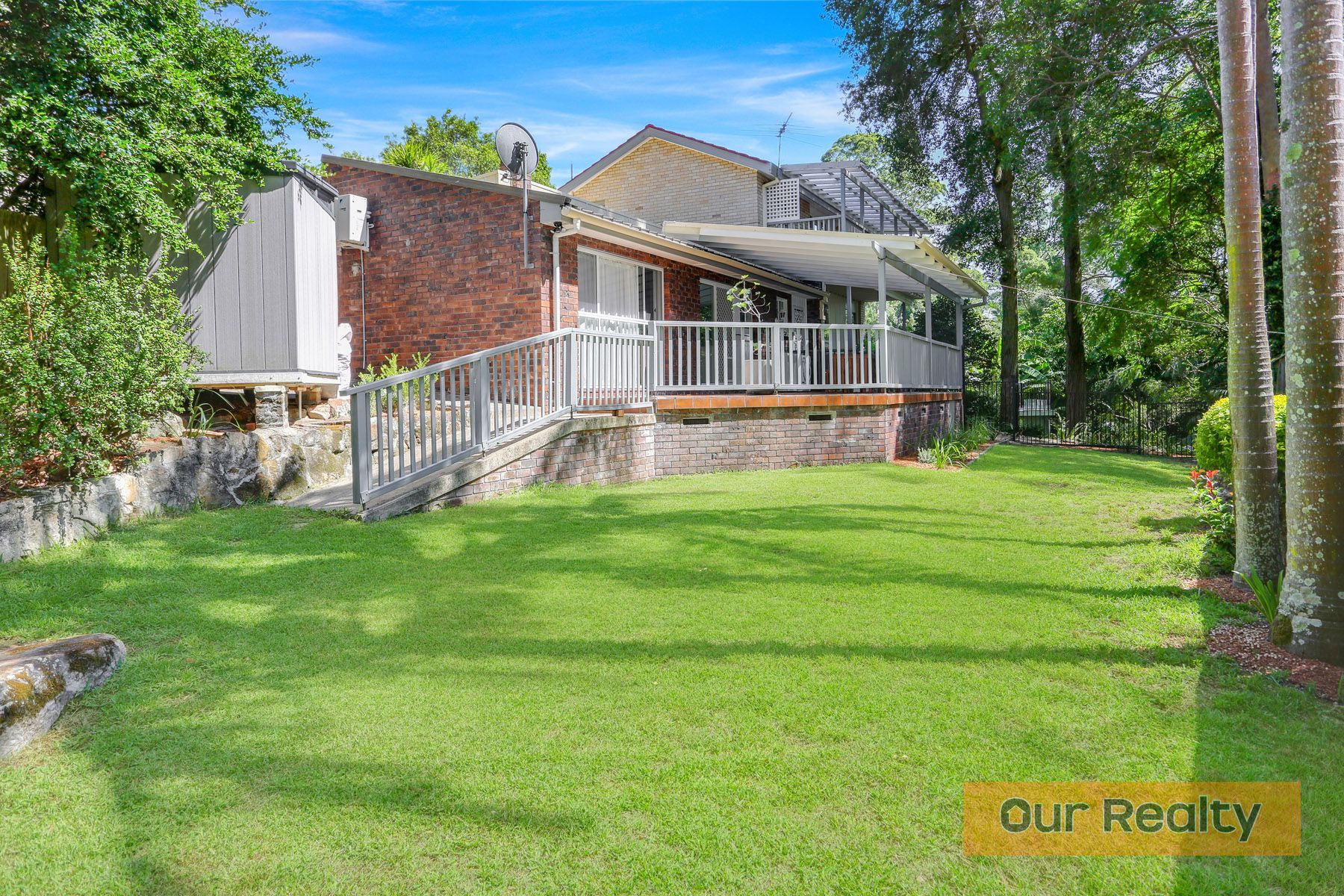 A balcony with a couch and a table with a view of a city.