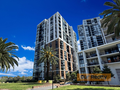 A balcony with a couch and a table with a view of a city.
