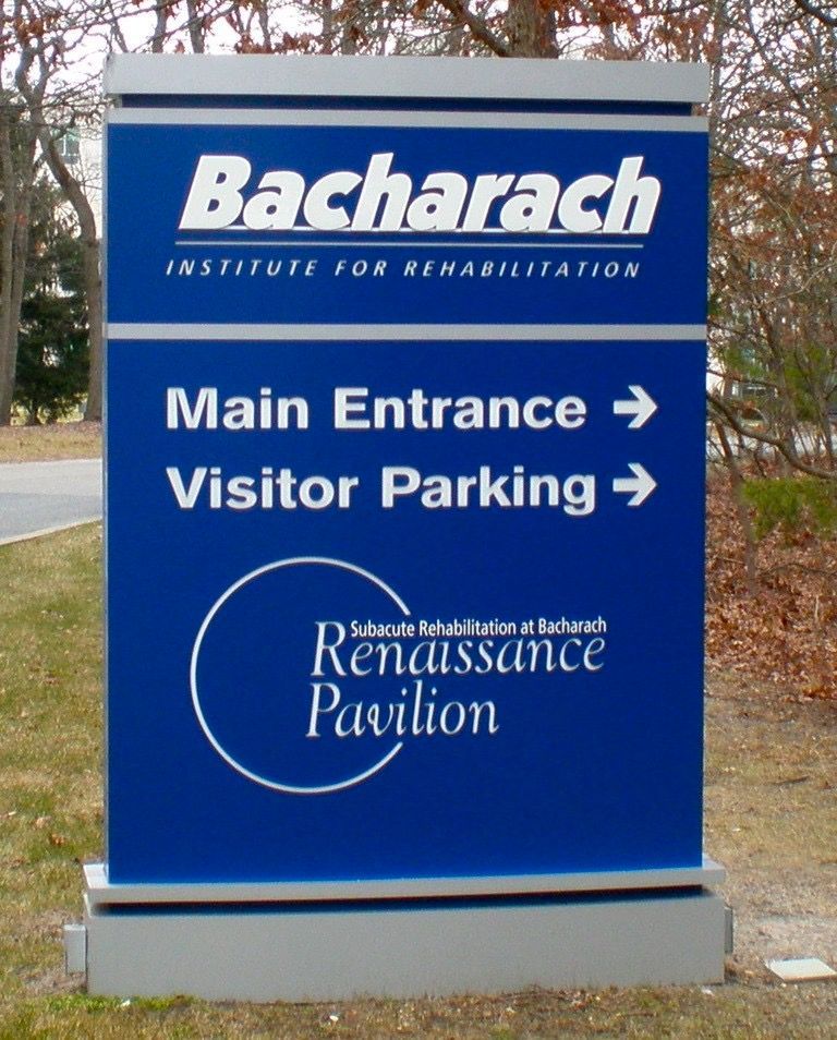 Blue and silver Bacharach Institute for Rehabilitation sign with directional arrows.