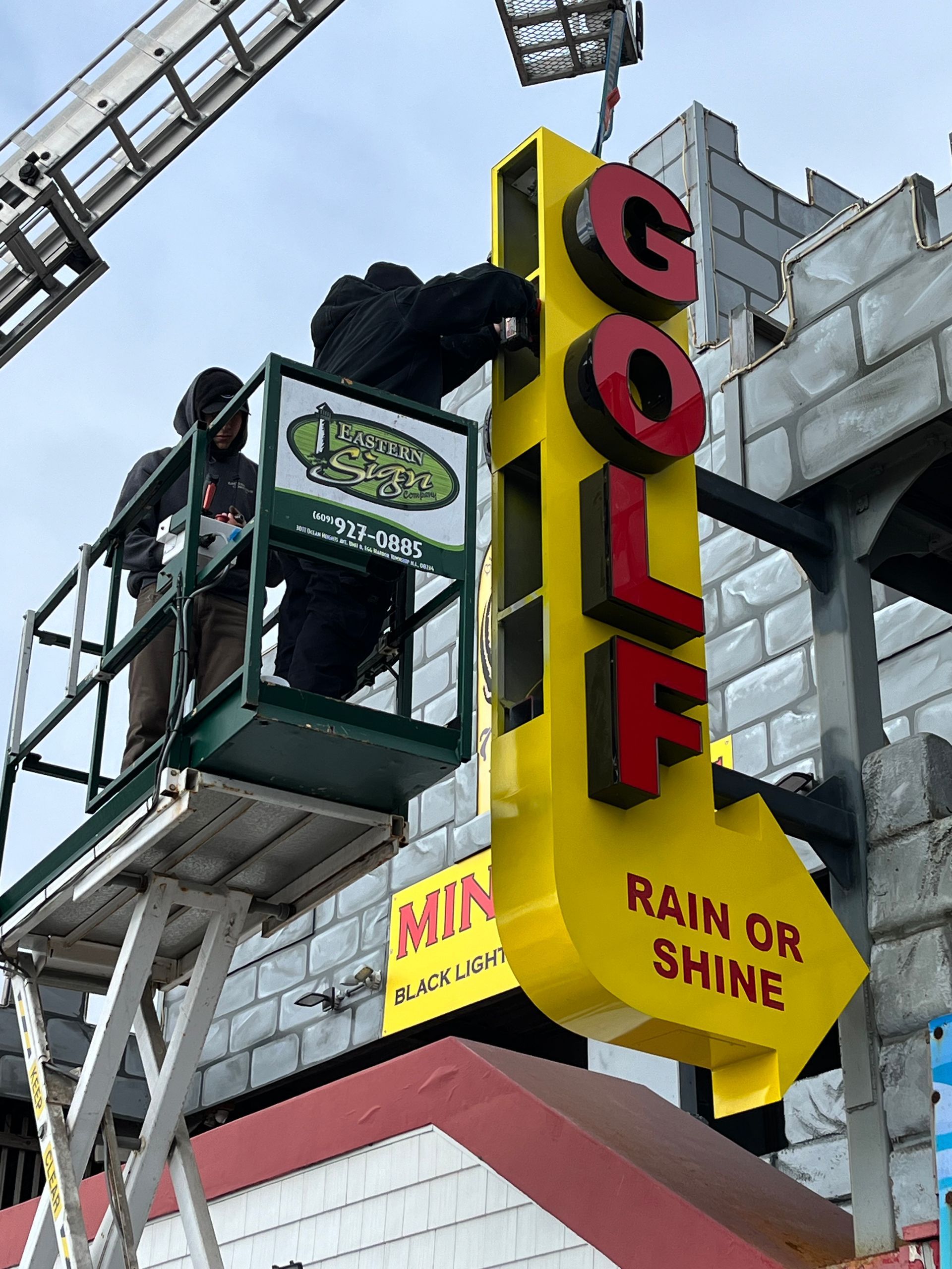 Worker on lift installing a bright yellow 