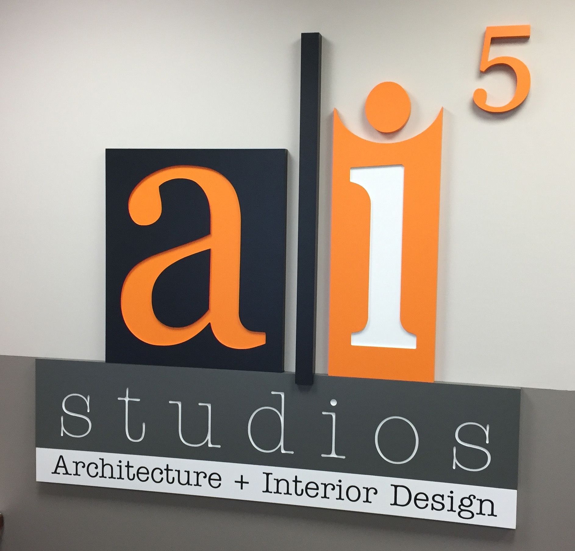 Sign for AI Studios, architecture and interior design, featuring orange and black letters and a number 5.