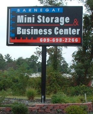 Sign for Barnegat Mini Storage & Business Center, black background, blue and red accents, 609-698-2266 phone number.