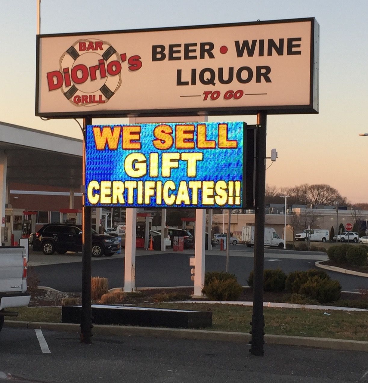 Sign for DiOrio's Grill, selling beer, wine, liquor to go.  A digital sign below advertises gift certificates.