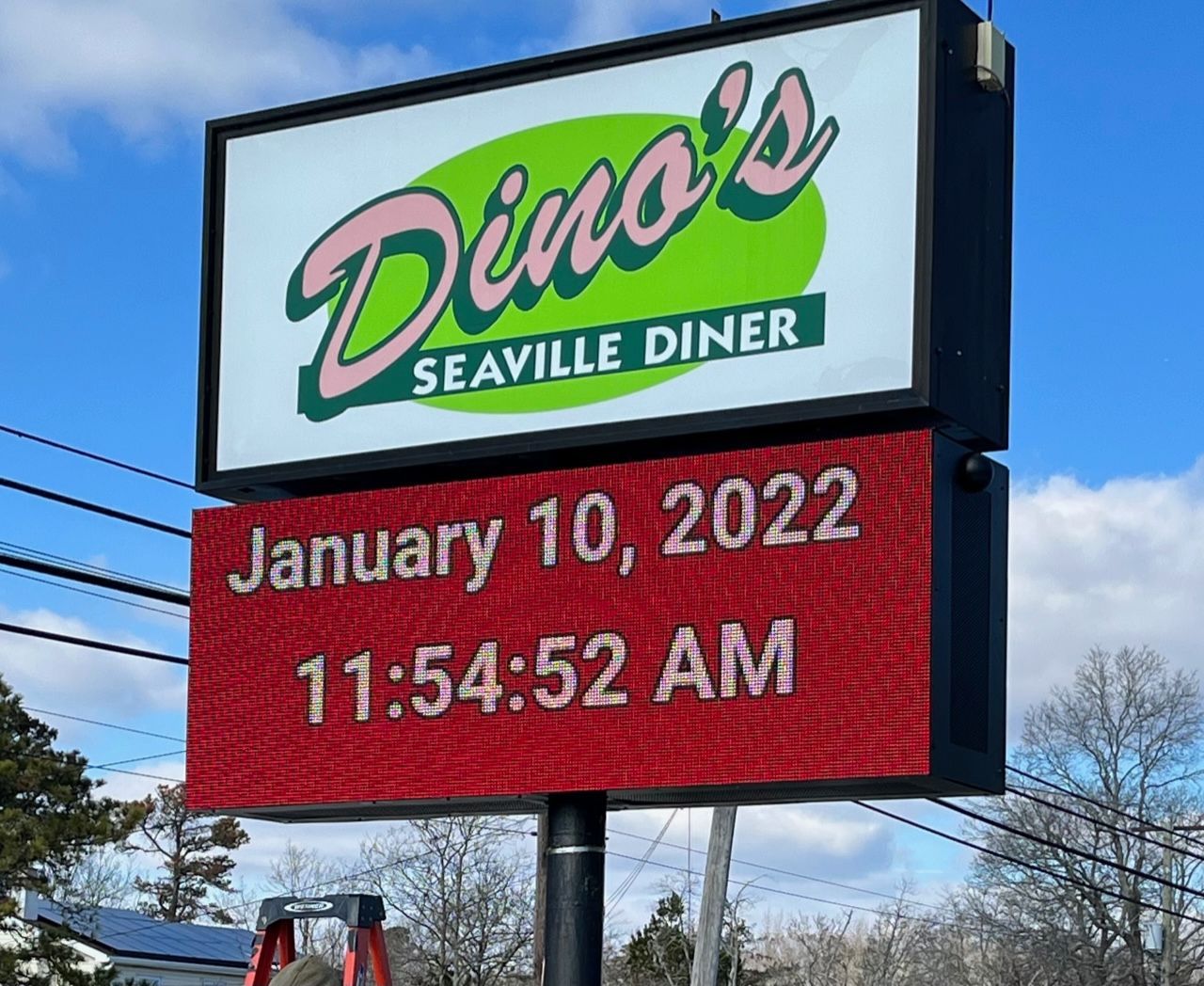 Sign for Dino's Seaville Diner with date and time on a red display: January 10, 2022, 11:54:52 AM.