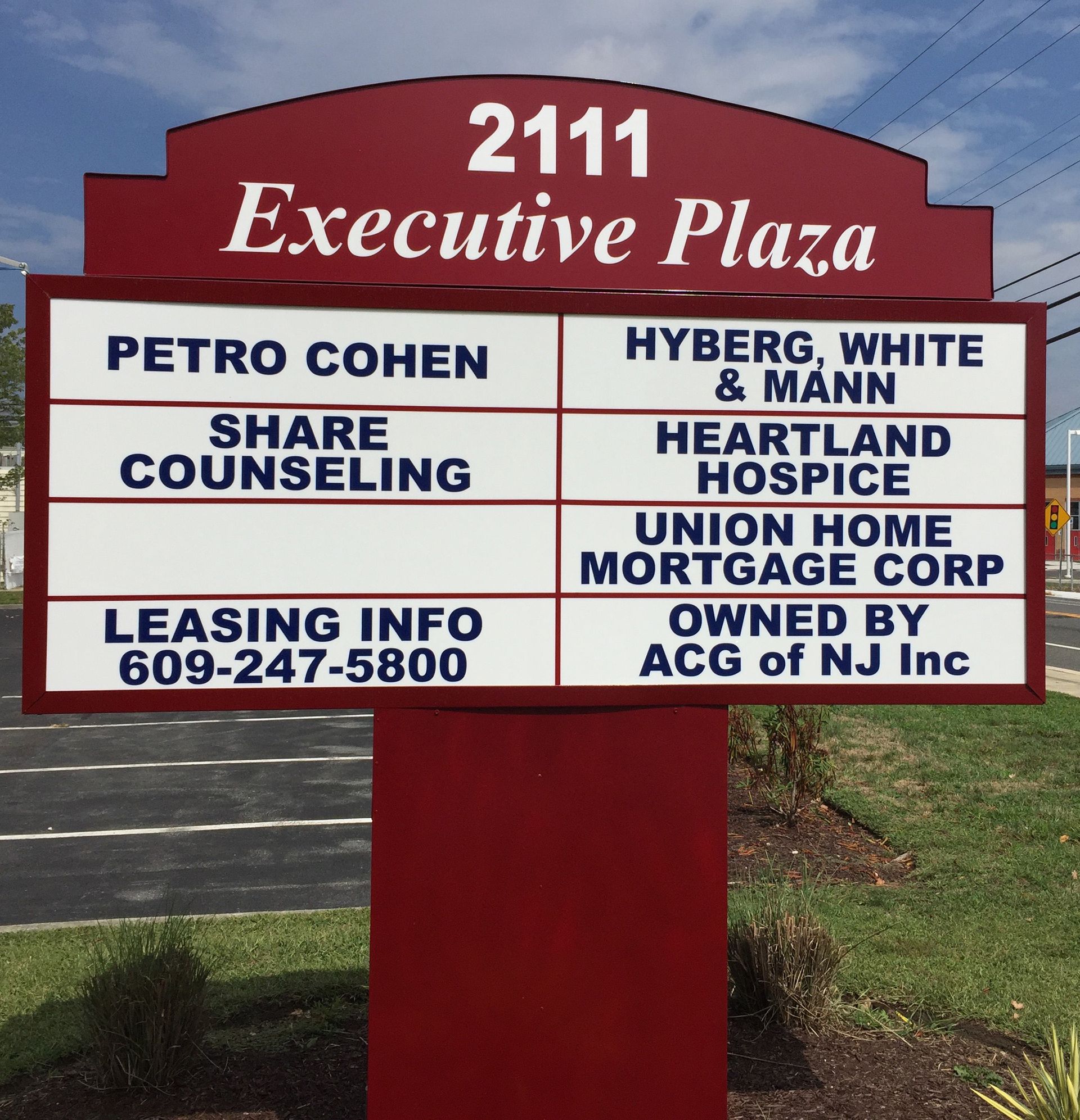 Sign for Executive Plaza with business names, contact info, and 
