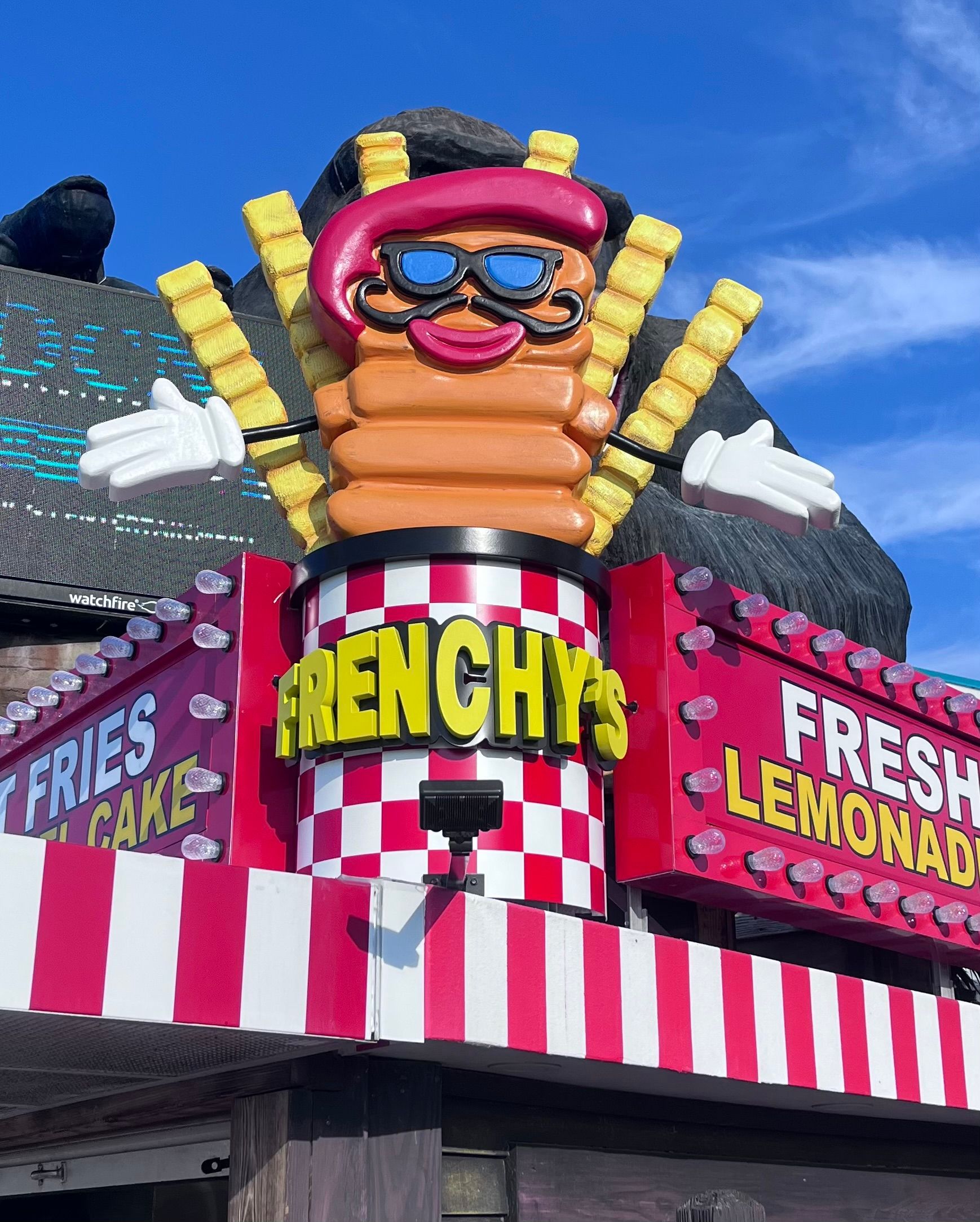 Sign for Frenchy's restaurant with a cartoon fries character wearing sunglasses and a beret.