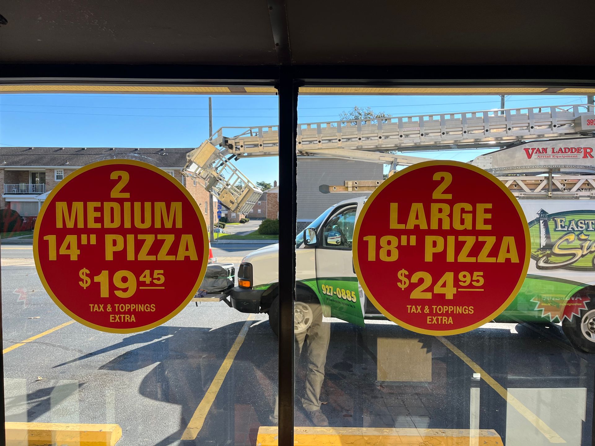 Two pizza deal signs on a window: 2 medium 14