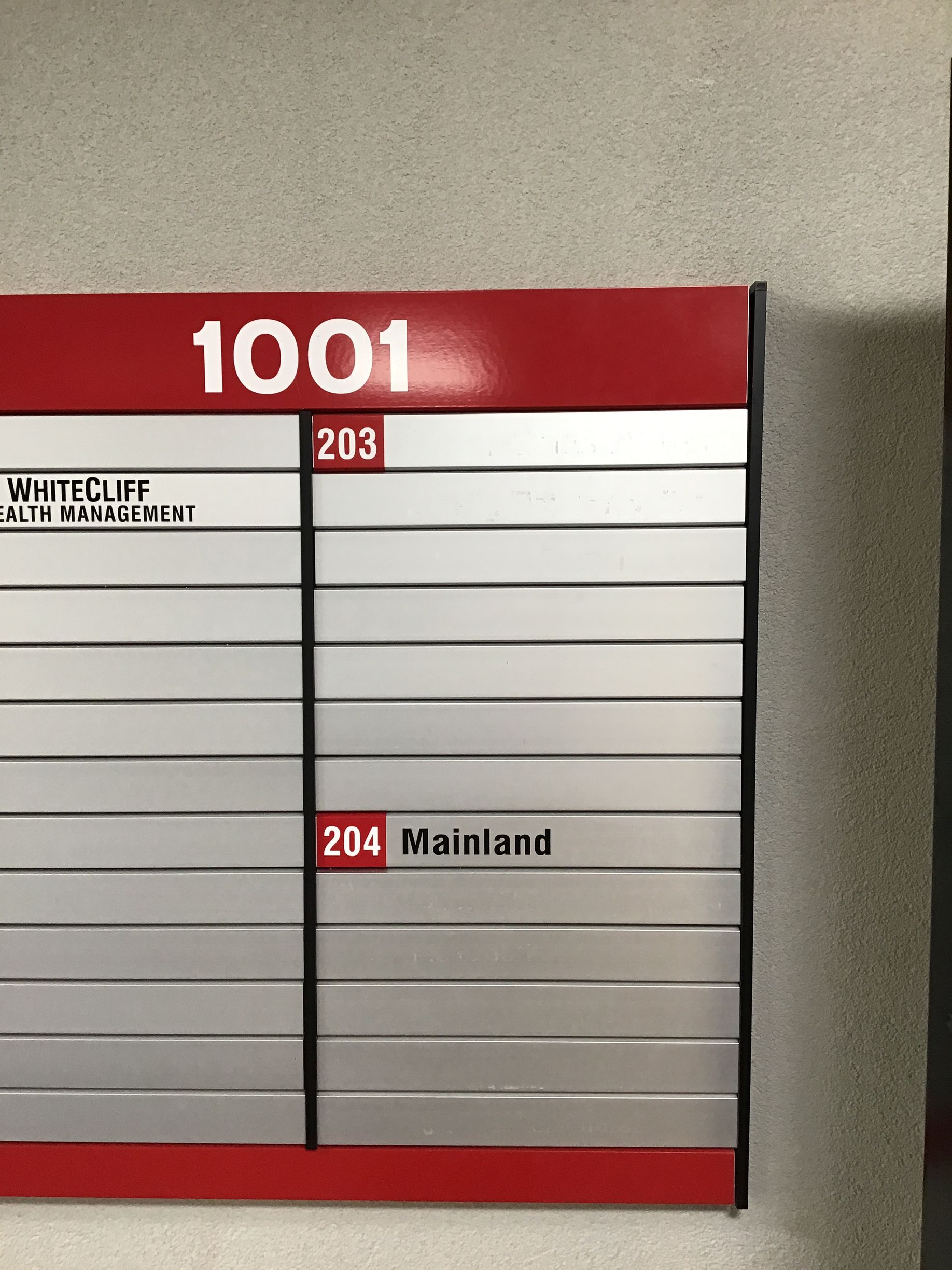 Directory sign with red and silver panels; includes room numbers: 1001, 203, and 204.
