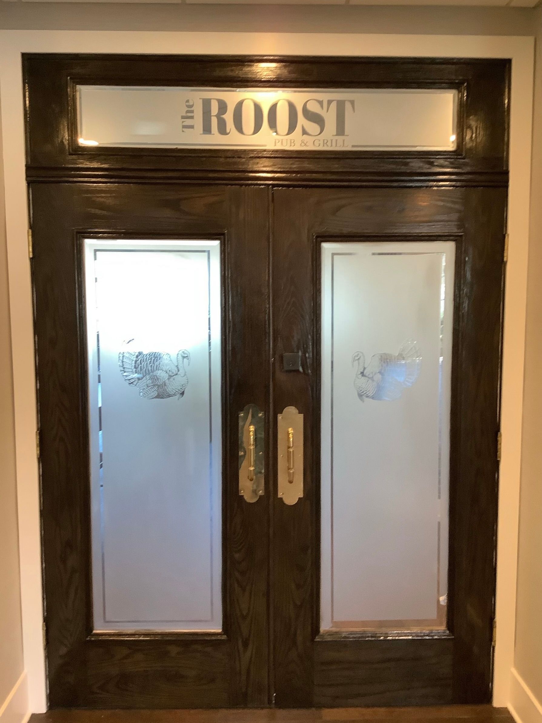 Dark wooden double doors with frosted glass panels. 