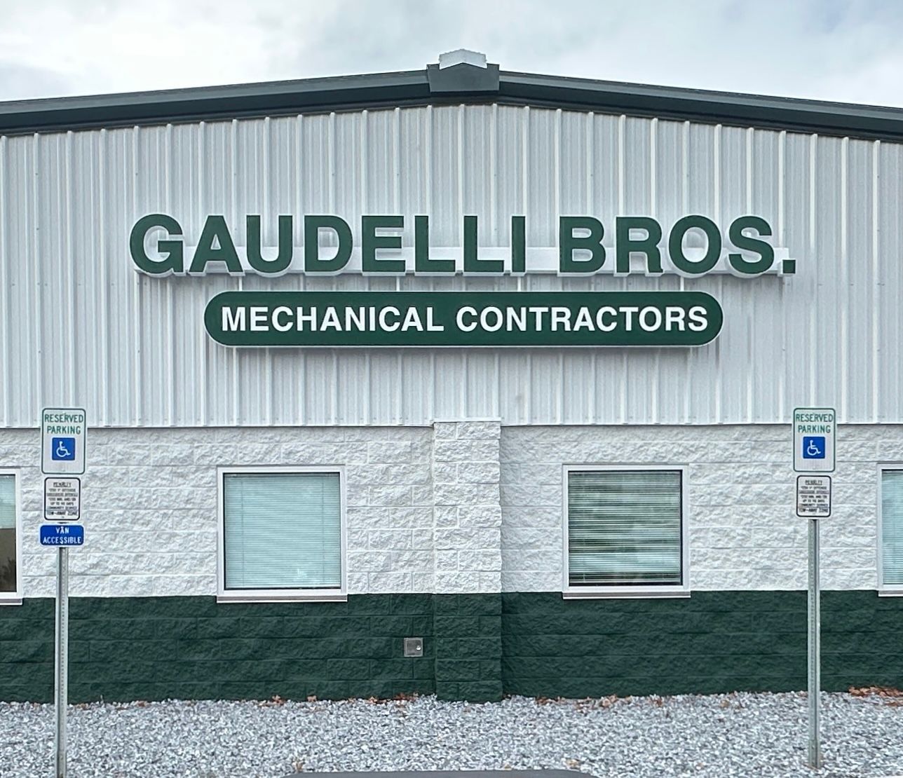 Sign for Galloway Auto & Tire Center, green and gold lettering, with beige frame, on a sunny day.