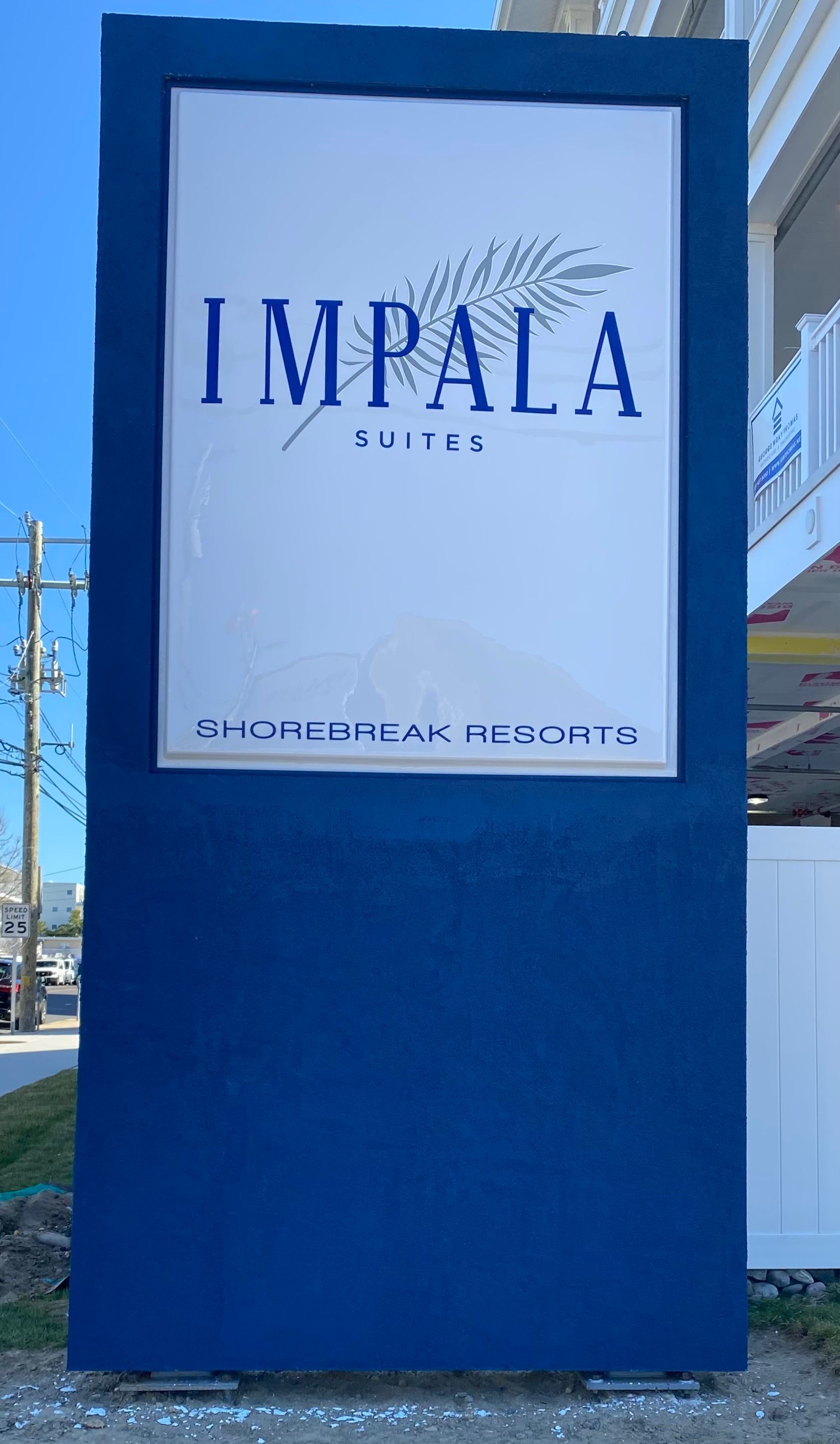 Sign for Impala Suites, blue and white with text and a palm frond graphic. Location: Outer Banks, NC.