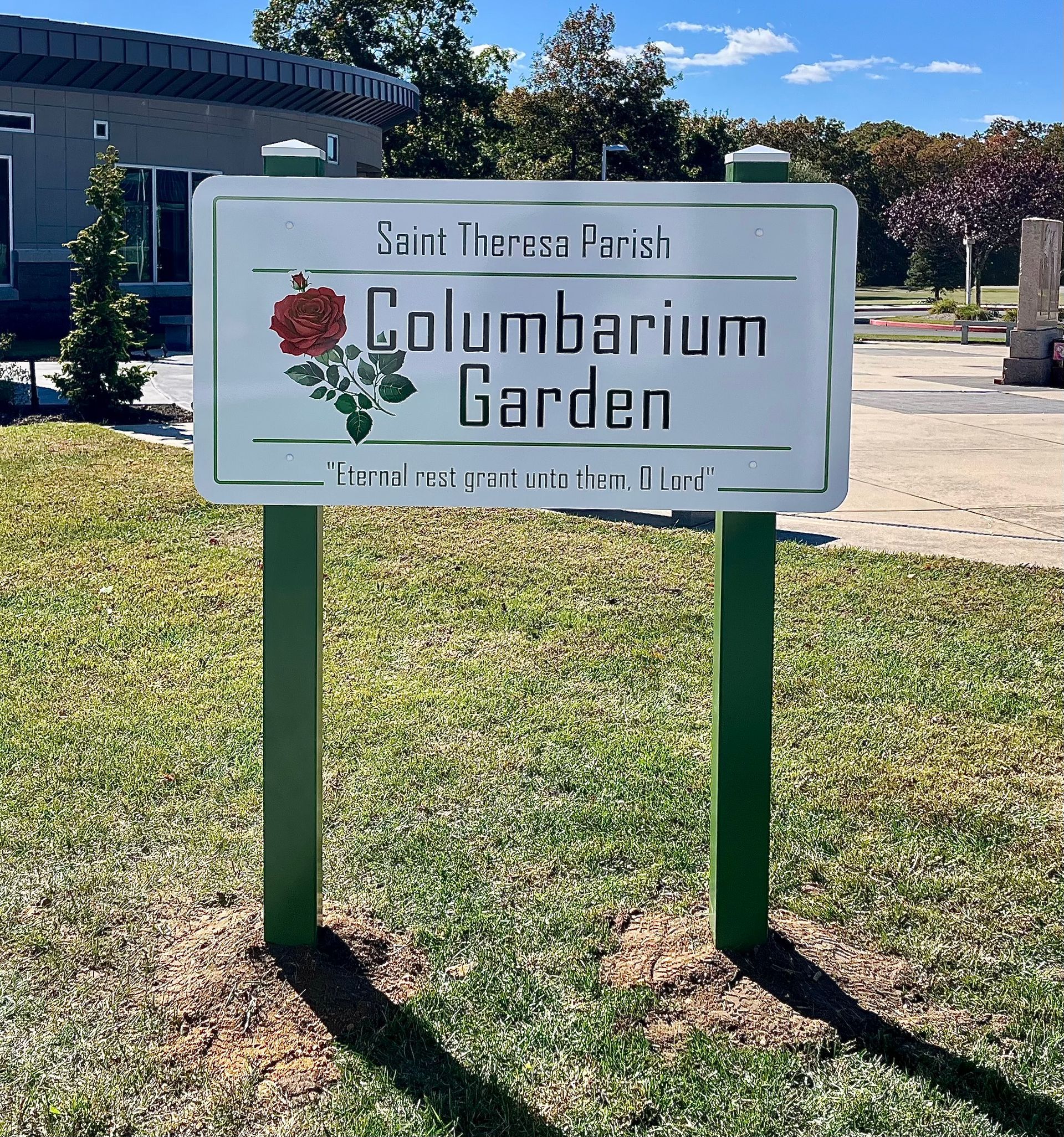 Sign for Saint Therese Church Columbarium Garden, white with green posts, rose graphic.