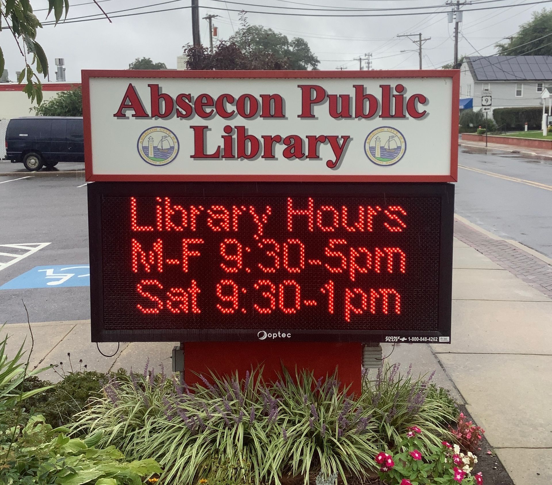 Sign for Absecon Public Library with hours displayed: M-F 9:30-5pm, Sat 9:30-1pm.