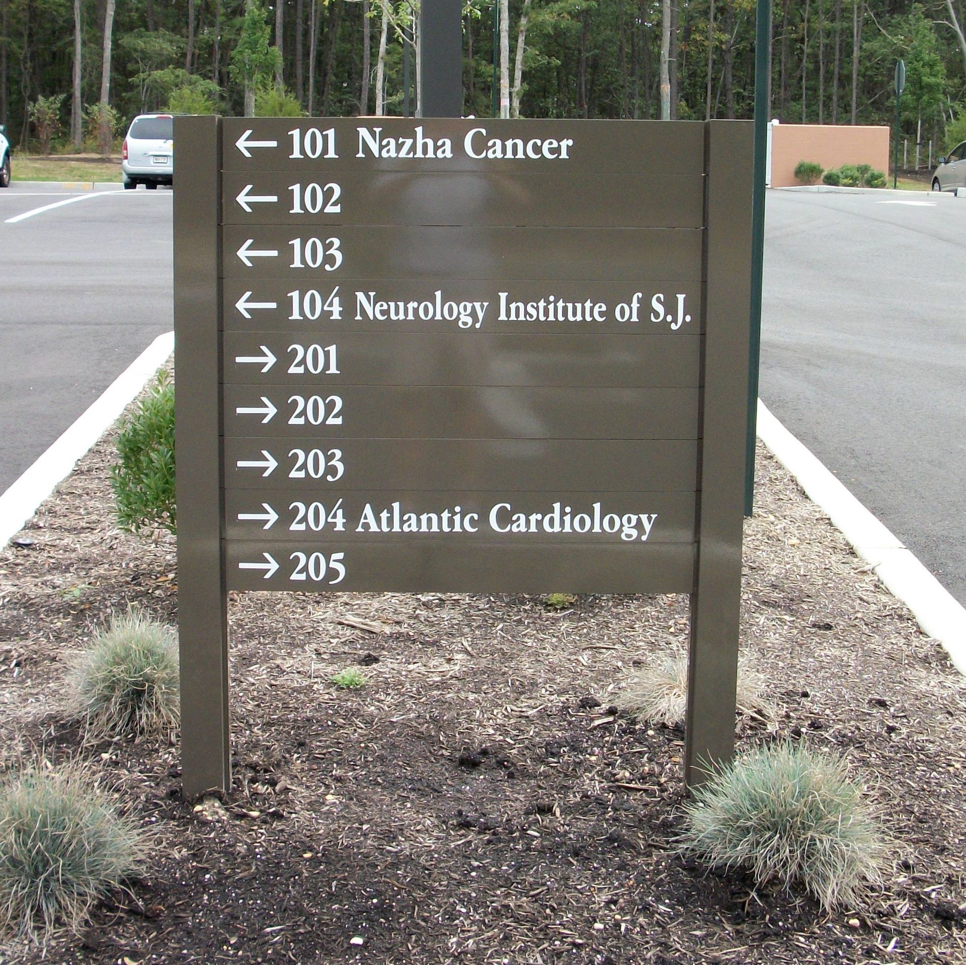 Brown sign with arrows indicating directions to medical offices.