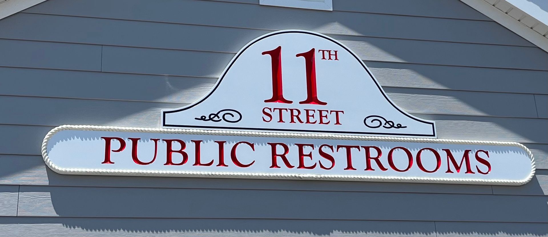 Sign for public restrooms on 11th Street. White background with red text.
