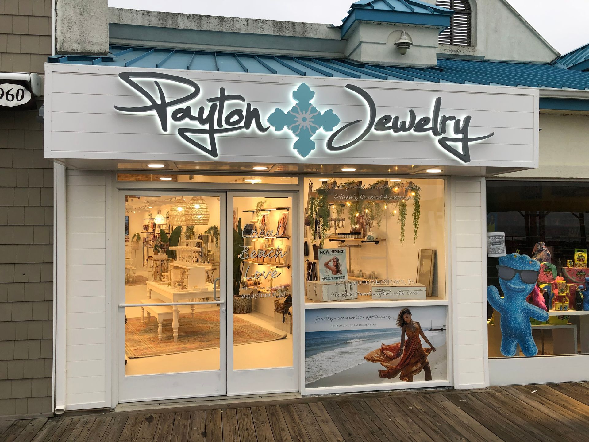 Payton Jewelry store front with illuminated sign and display window, set on a boardwalk.