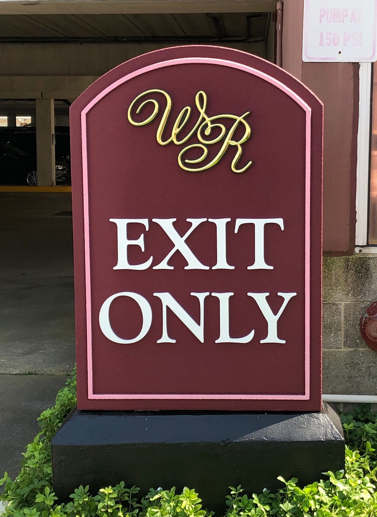 Sign, burgundy with pink trim, says 