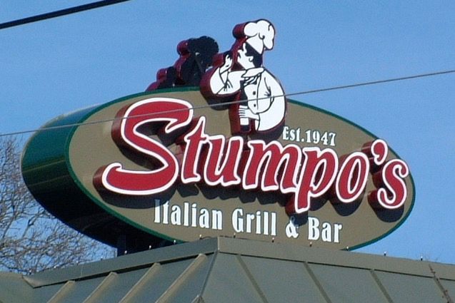 Sign for Stumpo's Italian Grill & Bar, with a chef logo, red and white lettering against a brown background, est. 1947.