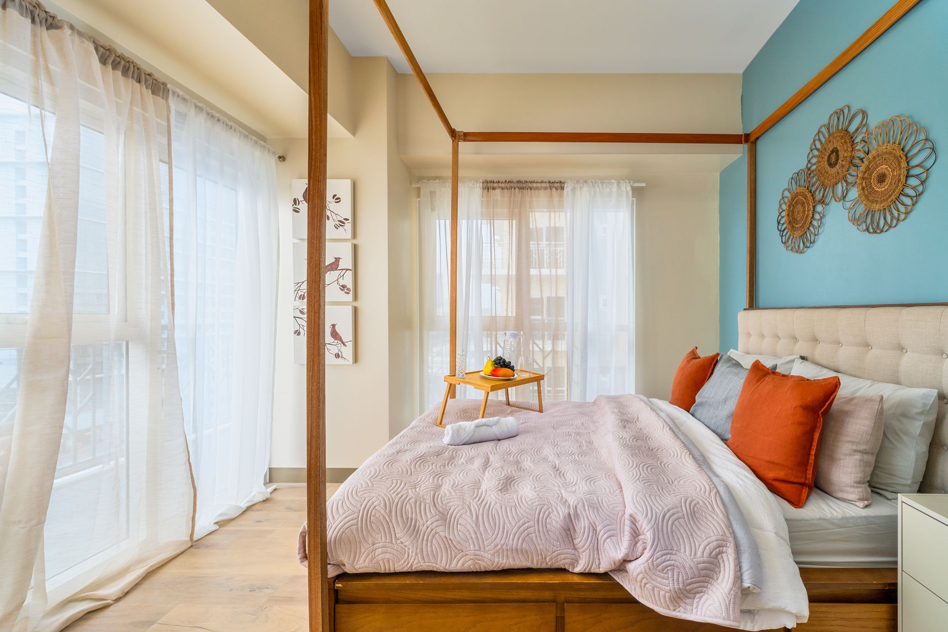 A bedroom with a canopy bed and lots of windows.