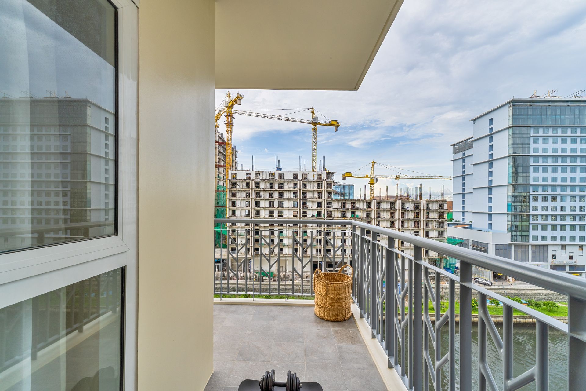 A balcony with a dumbbell on it and a view of a building under construction.