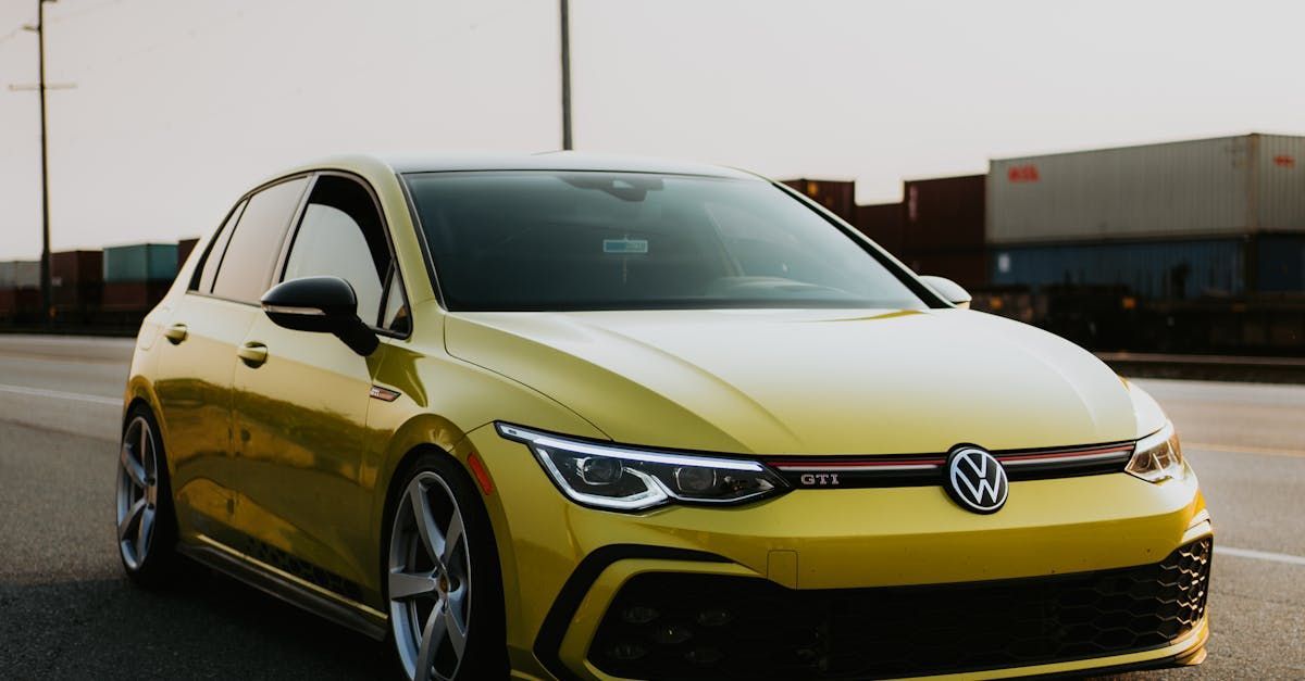 A yellow volkswagen golf is parked on the side of the road.