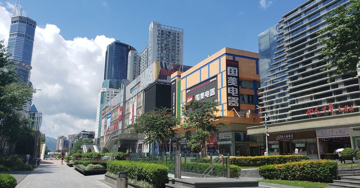A city street with a lot of buildings, shops and trees on a sunny day.  Shops near Bayshore Luxe by Prime, Manila