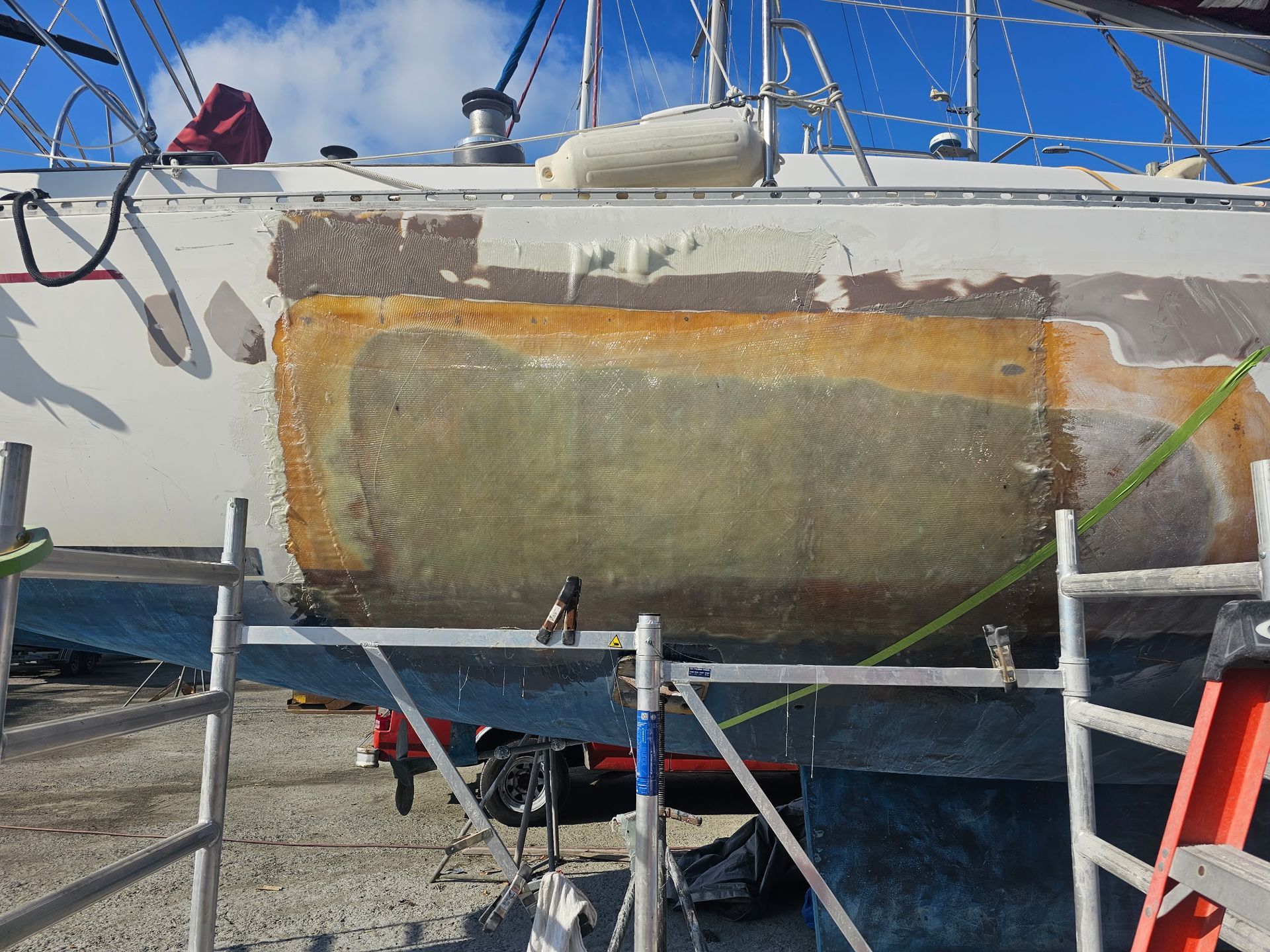 A boat is sitting on a scaffolding with a ladder in front of it.