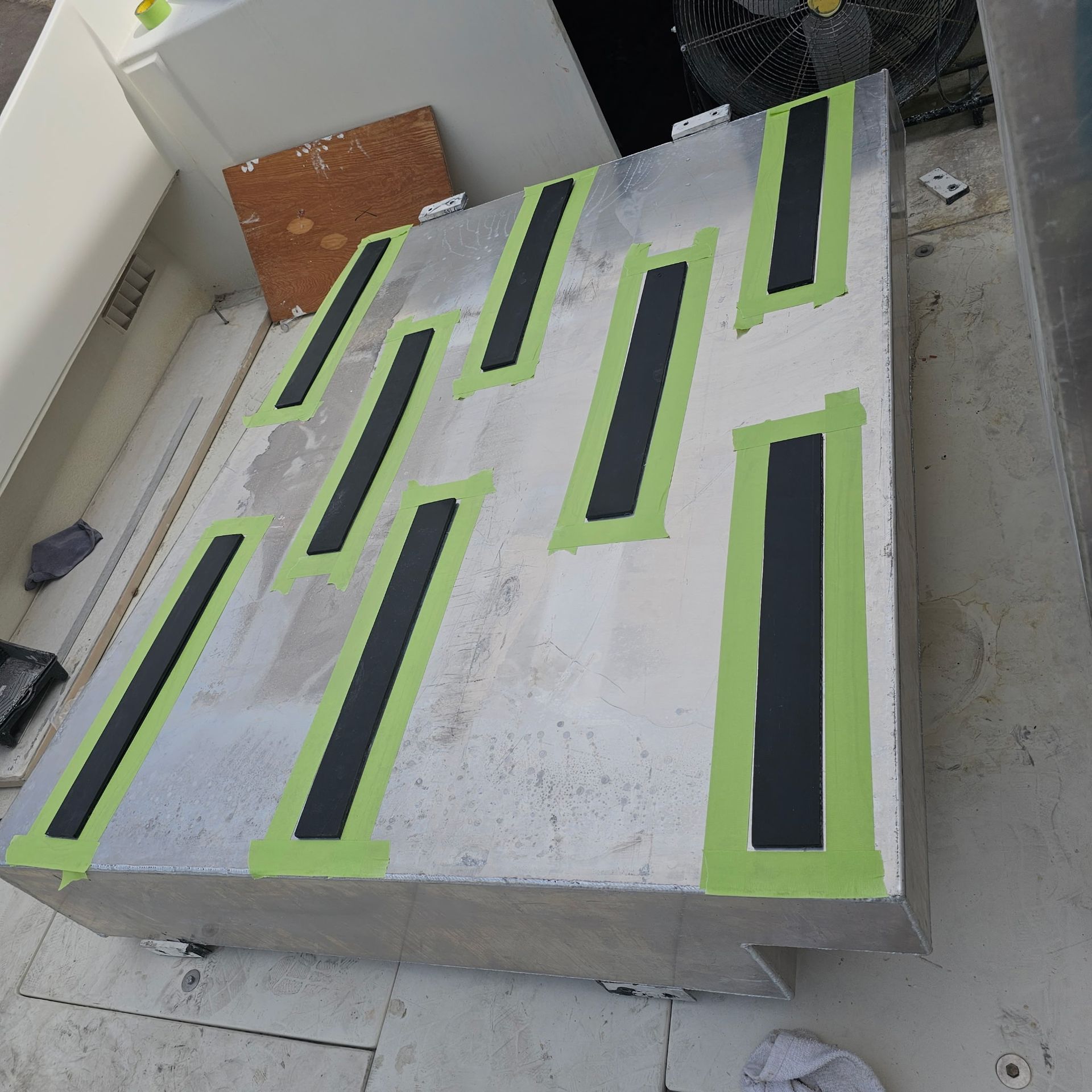 A piece of aluminum with black and green tape on it