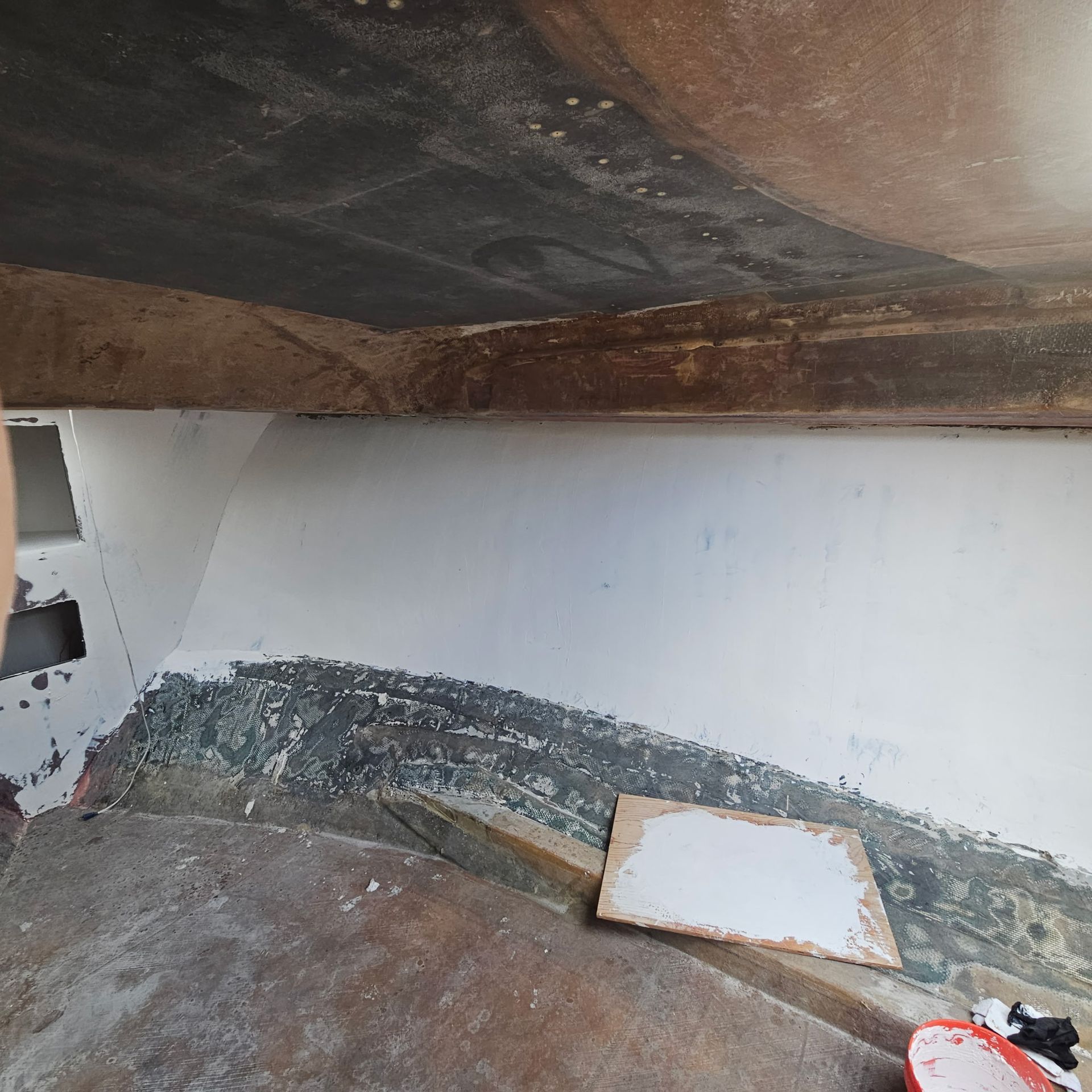 A person is standing in a room with a white board on the floor