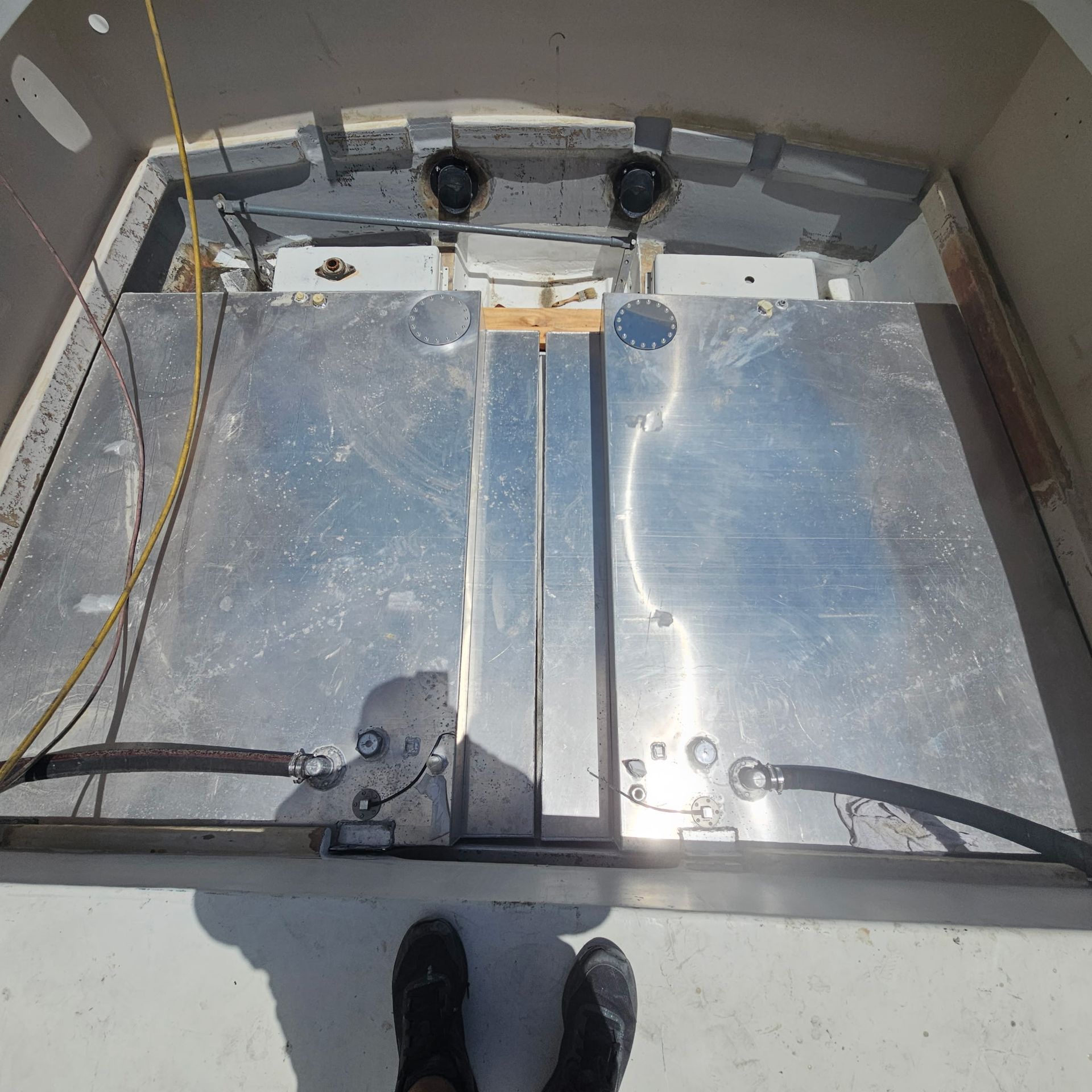 A person standing in front of a stainless steel tank on a boat