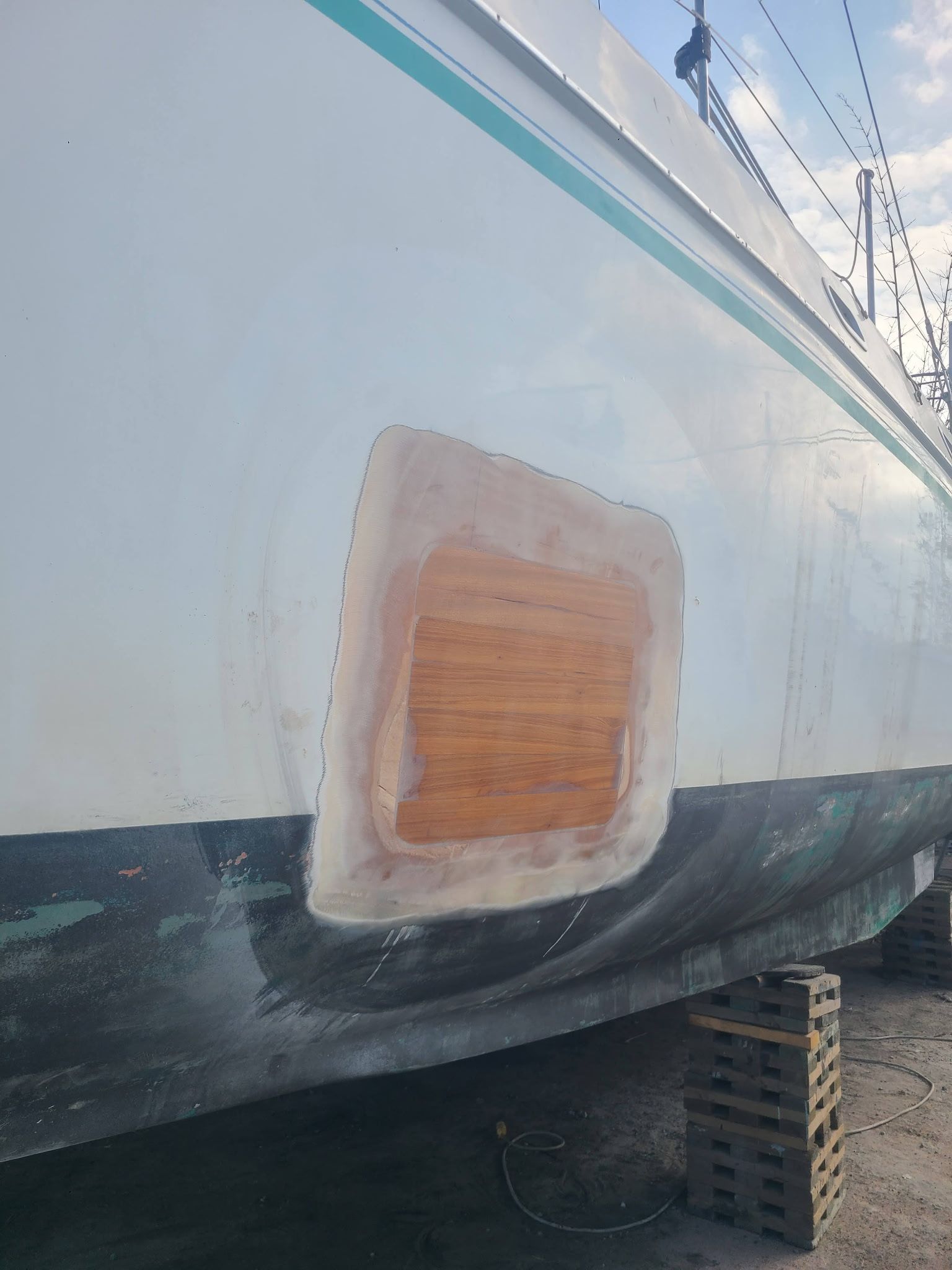 A boat with a hole in the side is being repaired.