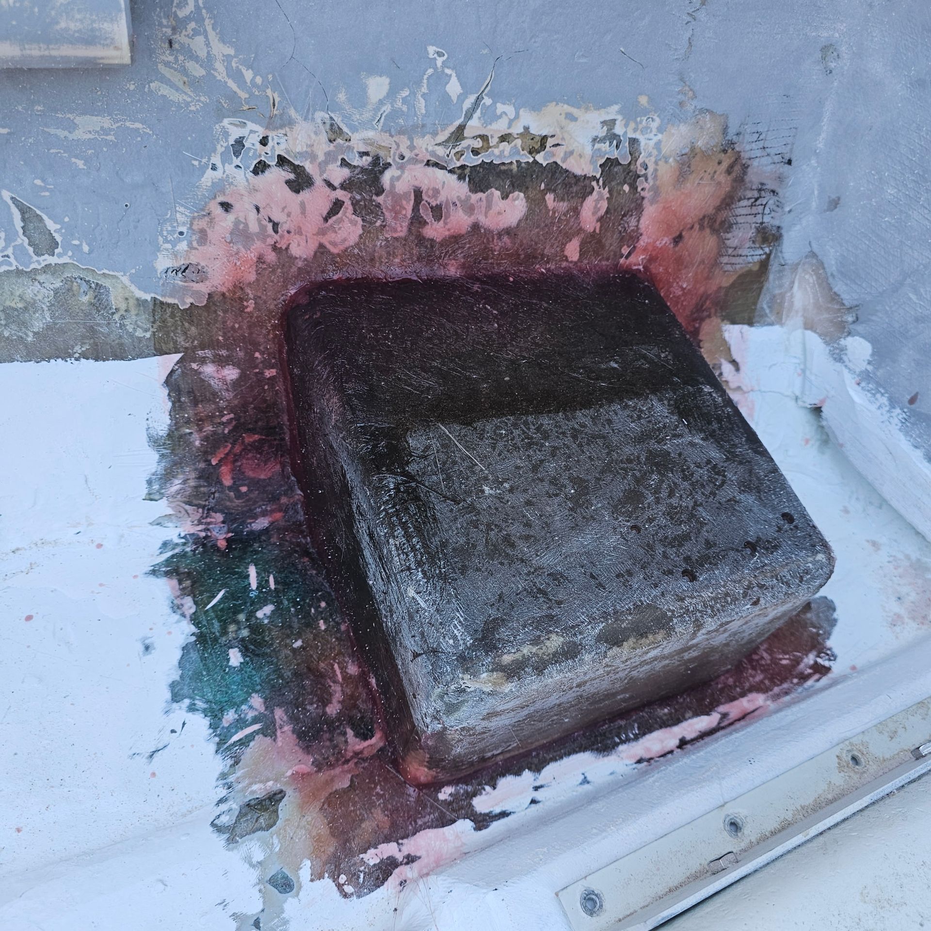 A piece of concrete is sitting on a white surface