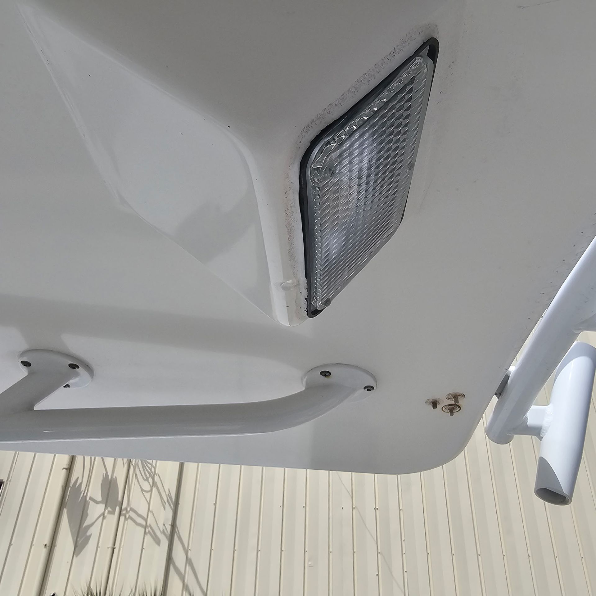 A white boat with a light on top of it